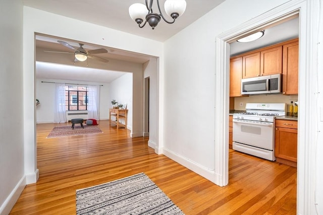 corridor featuring light hardwood / wood-style floors and a notable chandelier