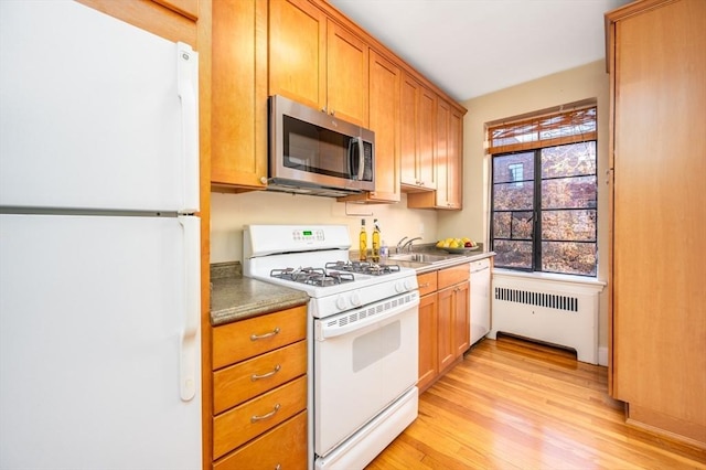 kitchen with sink, light hardwood / wood-style flooring, white appliances, and radiator