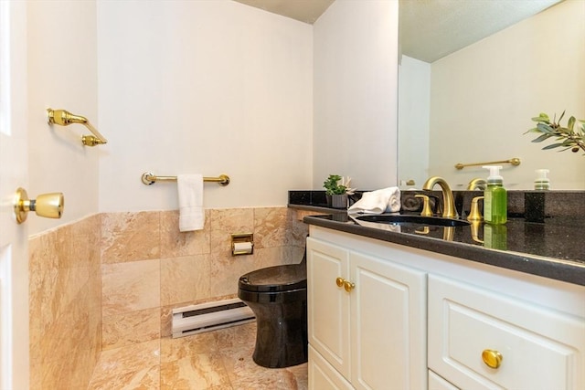 bathroom with visible vents, toilet, tile walls, vanity, and wainscoting