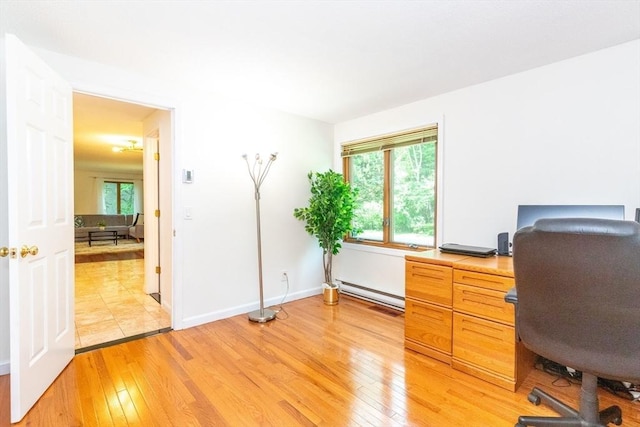 home office with a wealth of natural light, light wood-style flooring, and baseboards