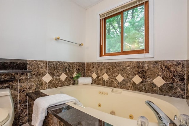 bathroom featuring a whirlpool tub and toilet