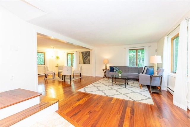 living room with plenty of natural light, a baseboard radiator, hardwood / wood-style flooring, and baseboards