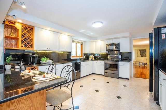 kitchen featuring tasteful backsplash, light tile patterned floors, open shelves, white cabinets, and black appliances
