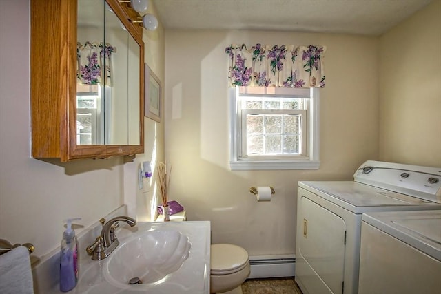 bathroom with separate washer and dryer, a baseboard heating unit, sink, and toilet