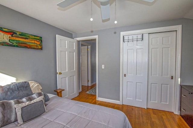 bedroom featuring light hardwood / wood-style flooring, a closet, ceiling fan, and vaulted ceiling