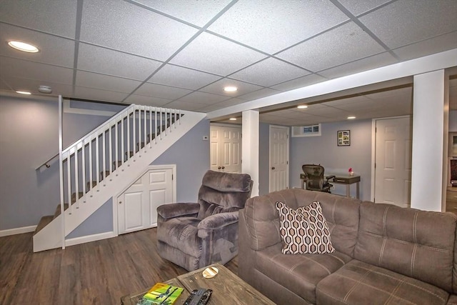 living room with dark wood-type flooring and a drop ceiling