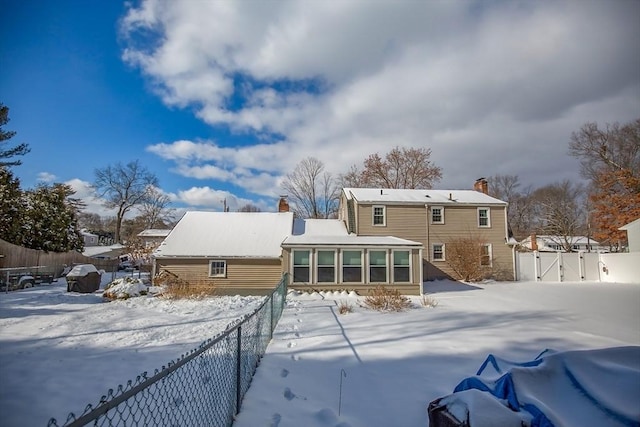 snow covered house with a sunroom