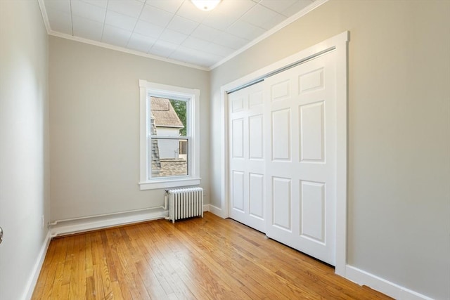 282 Palmer St, New Bedford, MA 02740 - unfurnished bedroom featuring radiator heating unit, ornamental molding, light wood-type flooring, a closet, and baseboards