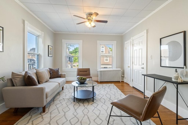 282 Palmer St, New Bedford, MA 02740 - living room featuring radiator heating unit, crown molding, wood finished floors, ceiling fan, and baseboards