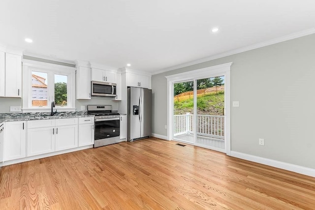 106 Pond St Unit U 30, Attleboro, MA 02703 - kitchen featuring appliances with stainless steel finishes, light stone counters, a sink, crown molding, and baseboards