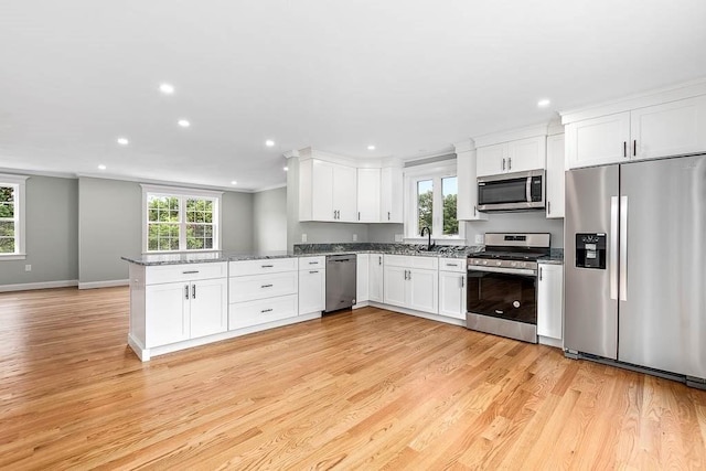 106 Pond St Unit U 30, Attleboro, MA 02703 - kitchen featuring appliances with stainless steel finishes, recessed lighting, a peninsula, light wood-type flooring, and crown molding