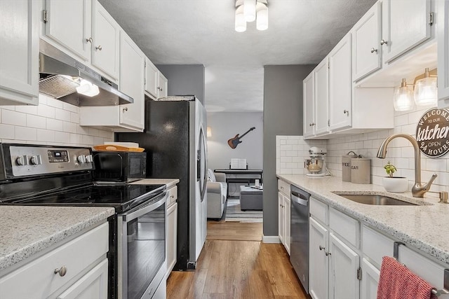 193 Patrick Rd Unit 193, Tewksbury, MA 01876 - kitchen with appliances with stainless steel finishes, under cabinet range hood, white cabinetry, light wood-style flooring, and tasteful backsplash
