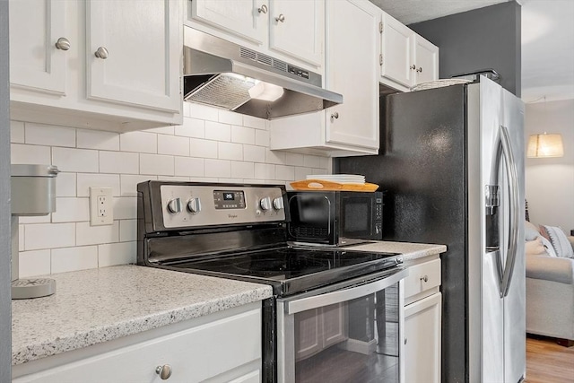 193 Patrick Rd Unit 193, Tewksbury, MA 01876 - kitchen with under cabinet range hood, stainless steel electric stove, black microwave, tasteful backsplash, and white cabinetry
