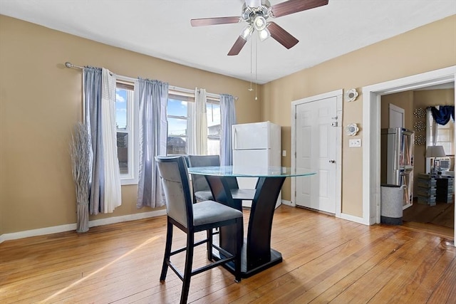 dining space with light wood-type flooring and ceiling fan