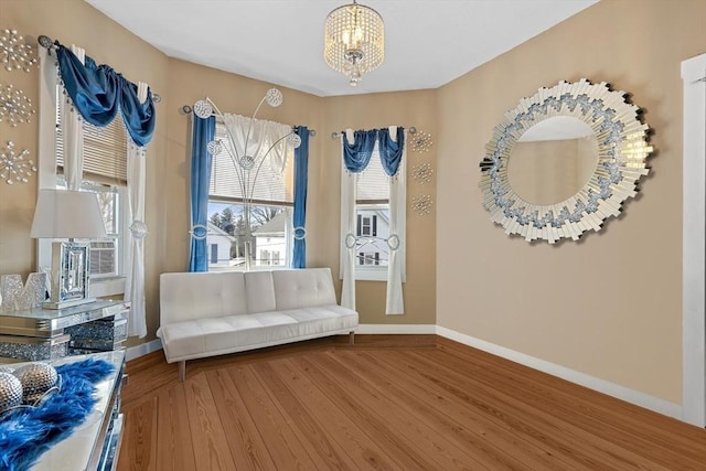 living area featuring hardwood / wood-style floors, a wealth of natural light, and an inviting chandelier