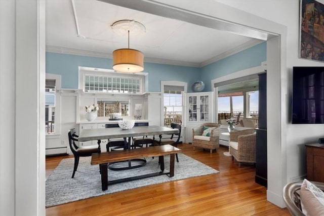 dining room with hardwood / wood-style floors, crown molding, and baseboard heating