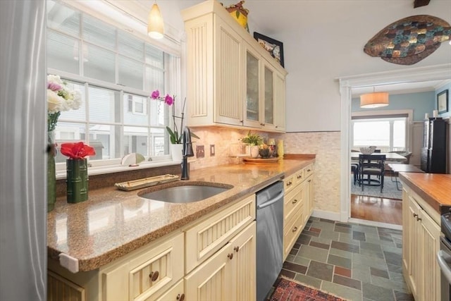 kitchen featuring dishwasher, cream cabinets, decorative light fixtures, and sink