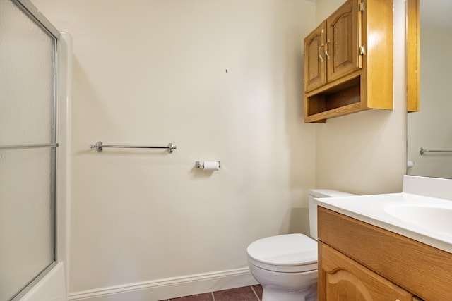 bathroom featuring tile patterned flooring, vanity, toilet, and a shower with door