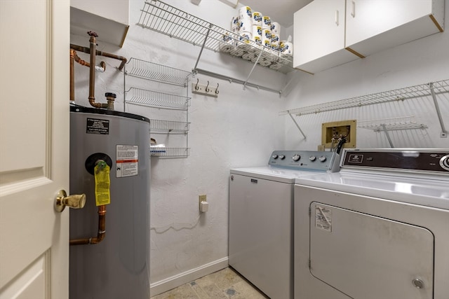 washroom featuring water heater, cabinets, and washing machine and clothes dryer