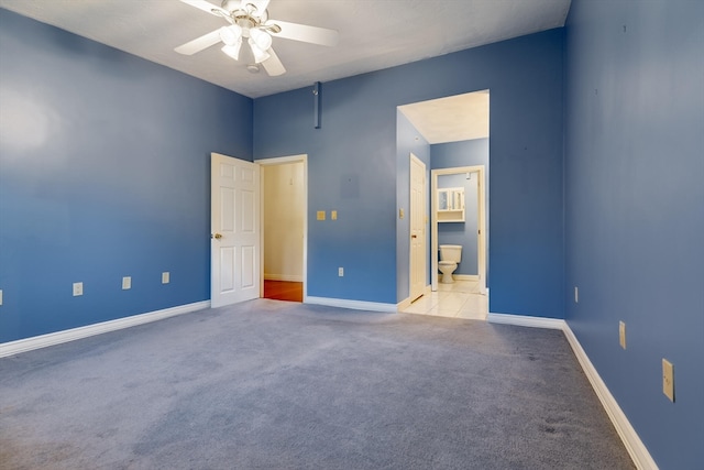 unfurnished bedroom with ceiling fan, ensuite bath, and light colored carpet