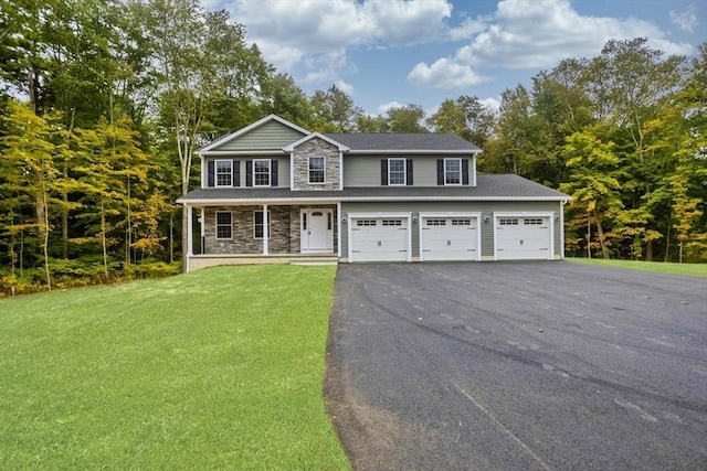 view of front of house featuring a porch, a garage, and a front lawn