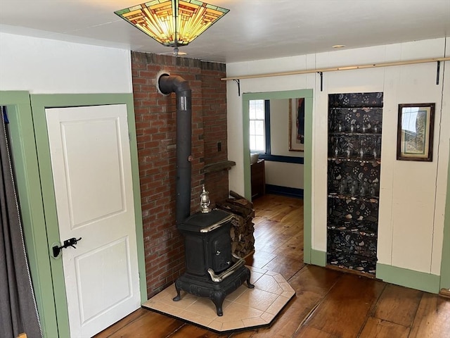 corridor with baseboards, brick wall, and hardwood / wood-style flooring