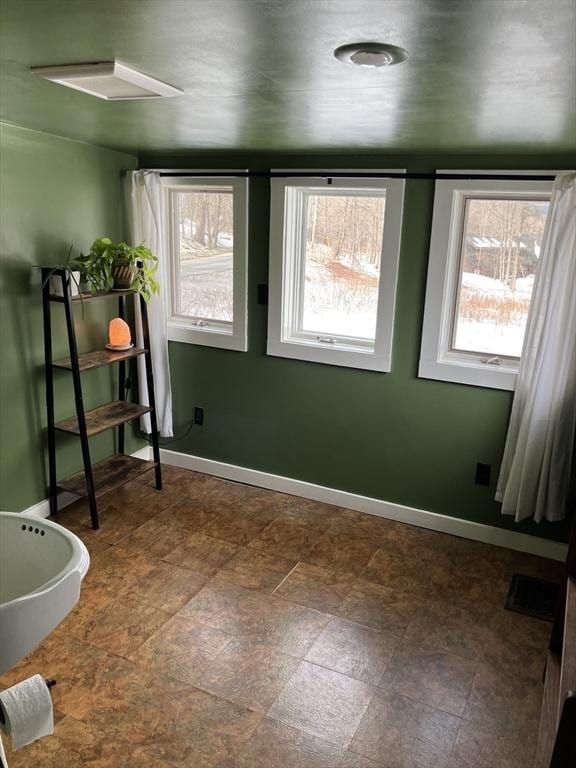 spare room with baseboards and visible vents