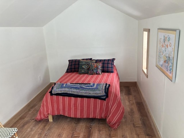 bedroom with dark wood finished floors, vaulted ceiling, and baseboards