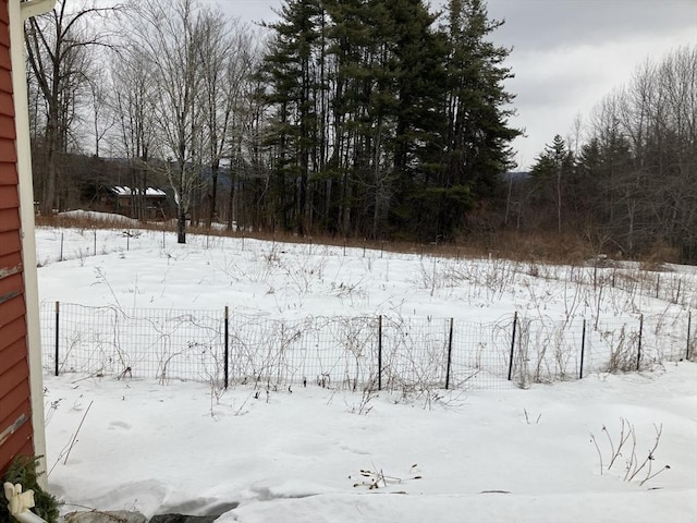 snowy yard featuring fence