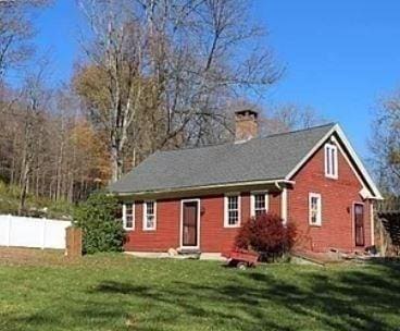 view of front of house with a front lawn, a chimney, fence, and brick siding