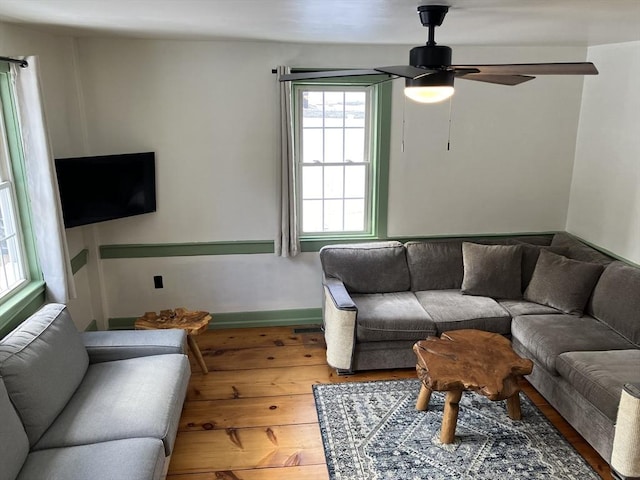 living area with ceiling fan and wood finished floors