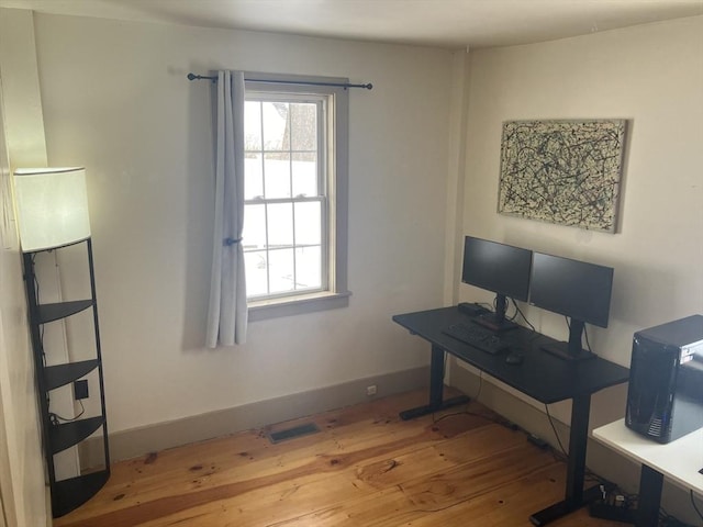 home office featuring a wealth of natural light, baseboards, and hardwood / wood-style flooring