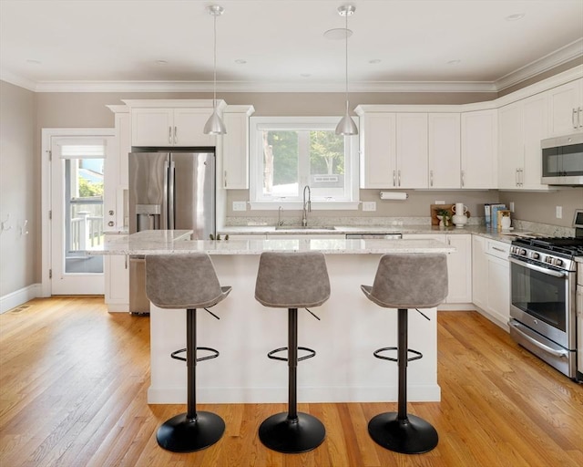 31 Neponset Ave, Boston, MA 02131 - kitchen featuring stainless steel appliances, a center island, white cabinets, a kitchen bar, and crown molding