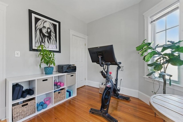 exercise area featuring baseboards and wood finished floors