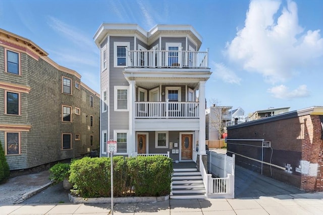 townhome / multi-family property with a porch and a balcony