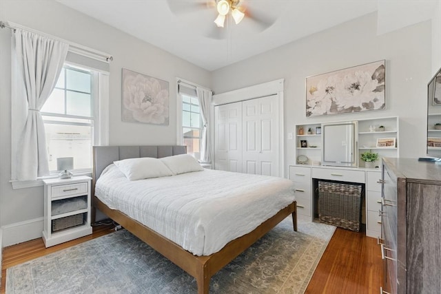 bedroom with ceiling fan, multiple windows, wood finished floors, and a closet
