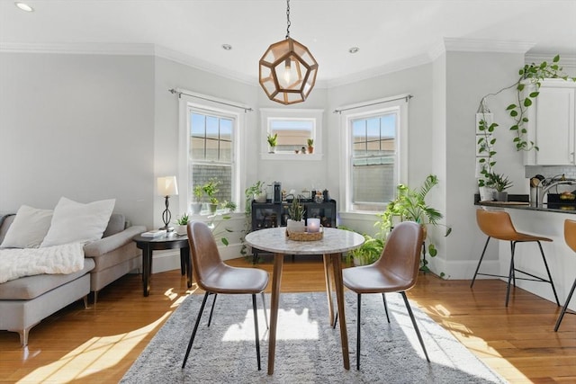 dining room featuring recessed lighting, baseboards, ornamental molding, and light wood finished floors