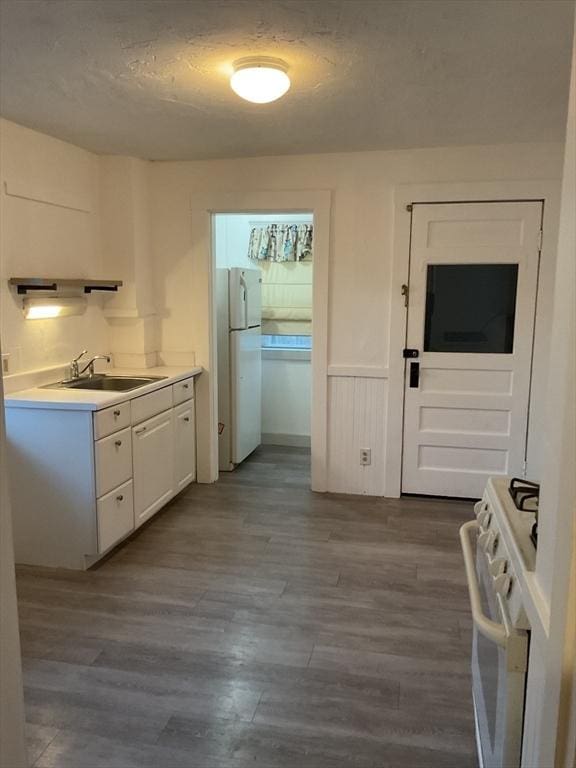 56 Riverview St, Dedham, MA 02026 - kitchen featuring a sink, white appliances, dark wood-style floors, white cabinetry, and light countertops