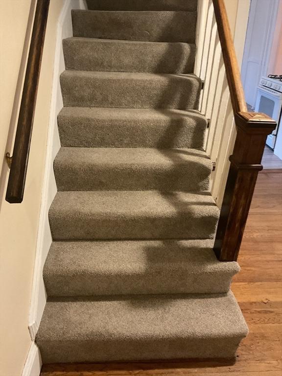 stairs featuring hardwood / wood-style floors