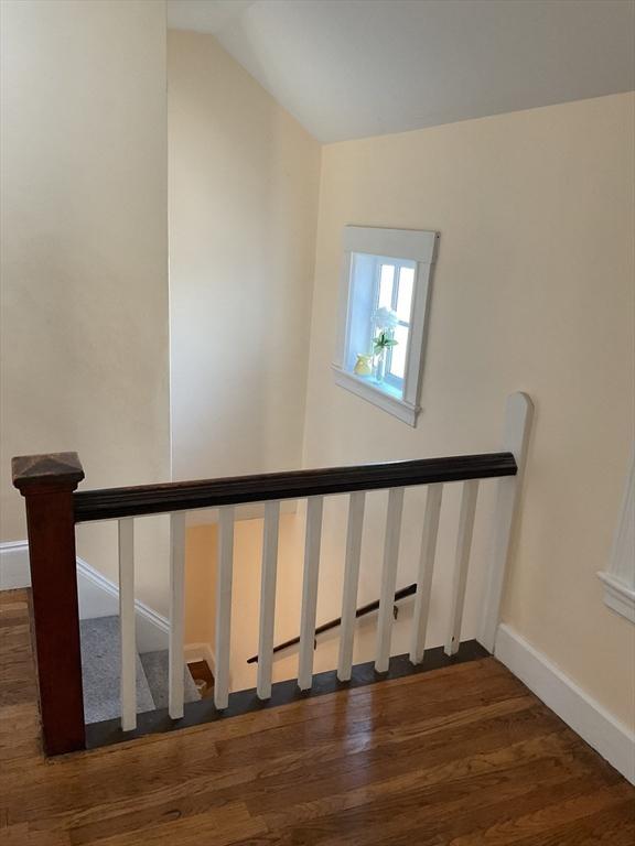 stairway featuring hardwood / wood-style floors and vaulted ceiling