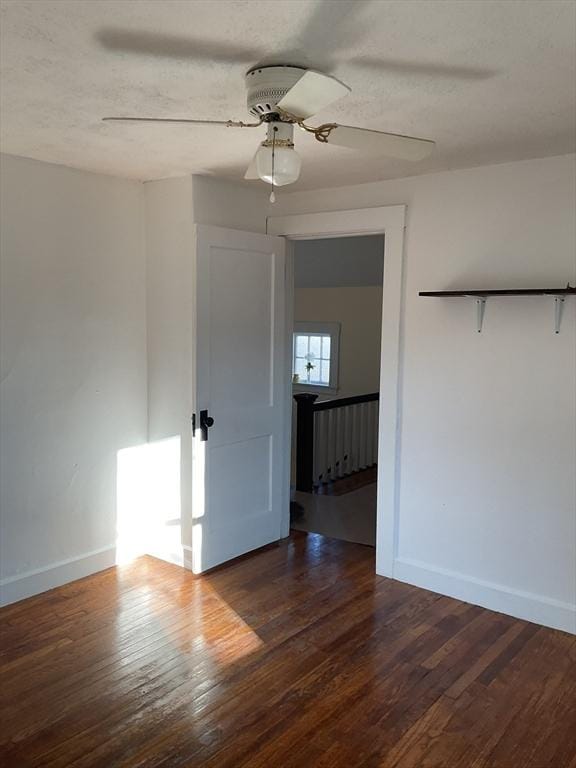 unfurnished room with ceiling fan, dark hardwood / wood-style flooring, and a textured ceiling