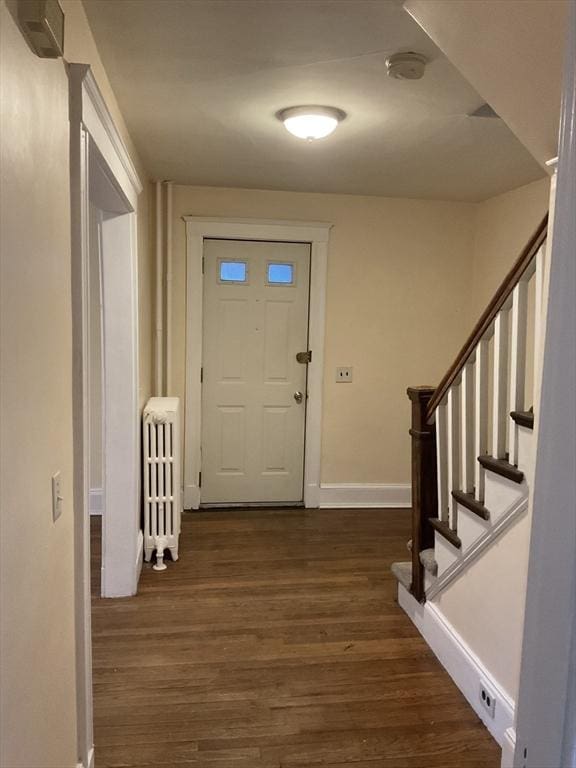 56 Riverview St, Dedham, MA 02026 - entryway featuring radiator heating unit, dark wood-style floors, baseboards, and stairway