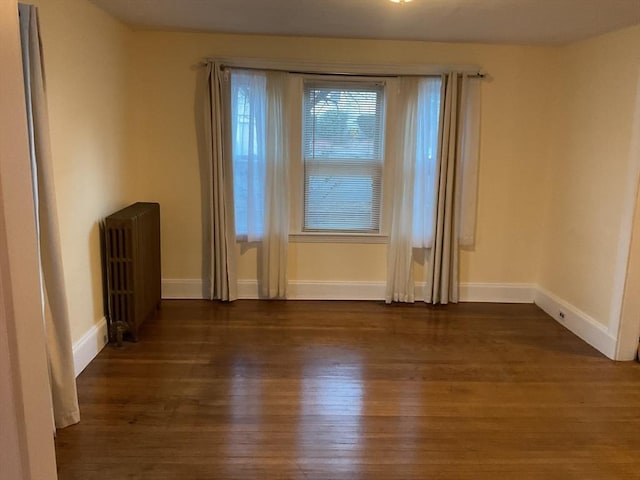 unfurnished room featuring dark hardwood / wood-style floors and radiator