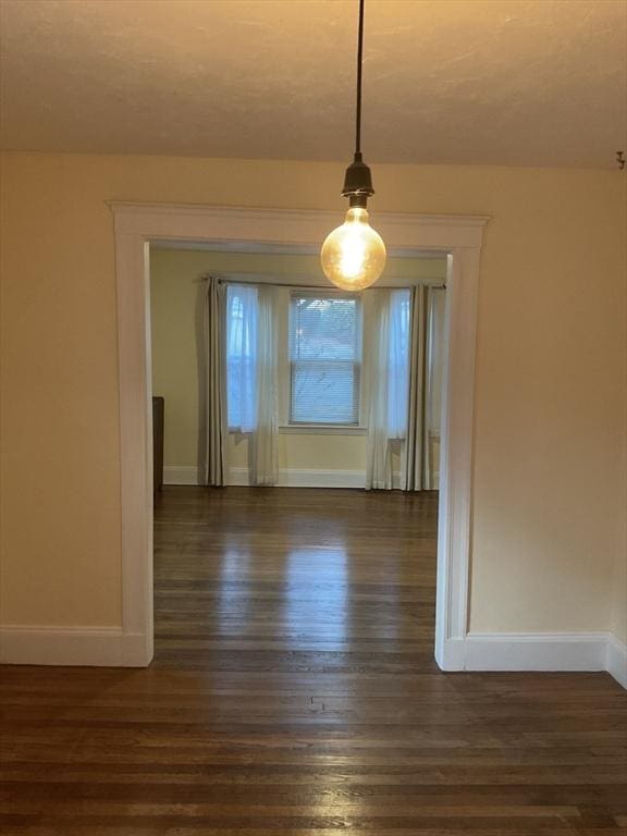 56 Riverview St, Dedham, MA 02026 - unfurnished dining area featuring dark wood-style flooring and baseboards