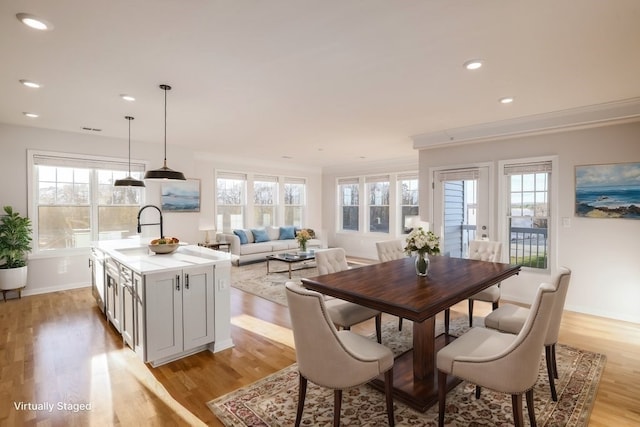 dining area with french doors, light hardwood / wood-style floors, sink, and crown molding