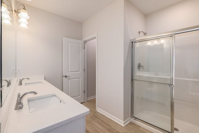 bathroom with an enclosed shower, wood-type flooring, and vanity