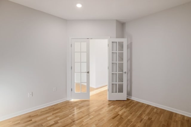 spare room with light hardwood / wood-style floors and french doors