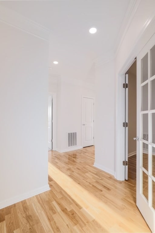 corridor featuring wood-type flooring and crown molding