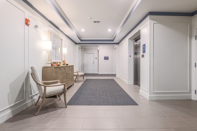 corridor featuring crown molding and a tray ceiling