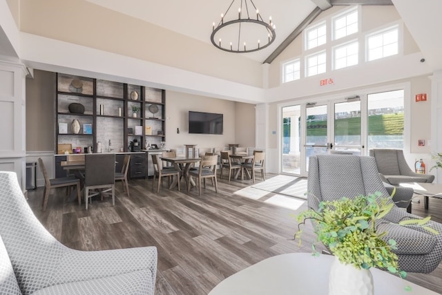 living room with high vaulted ceiling, hardwood / wood-style flooring, and a notable chandelier